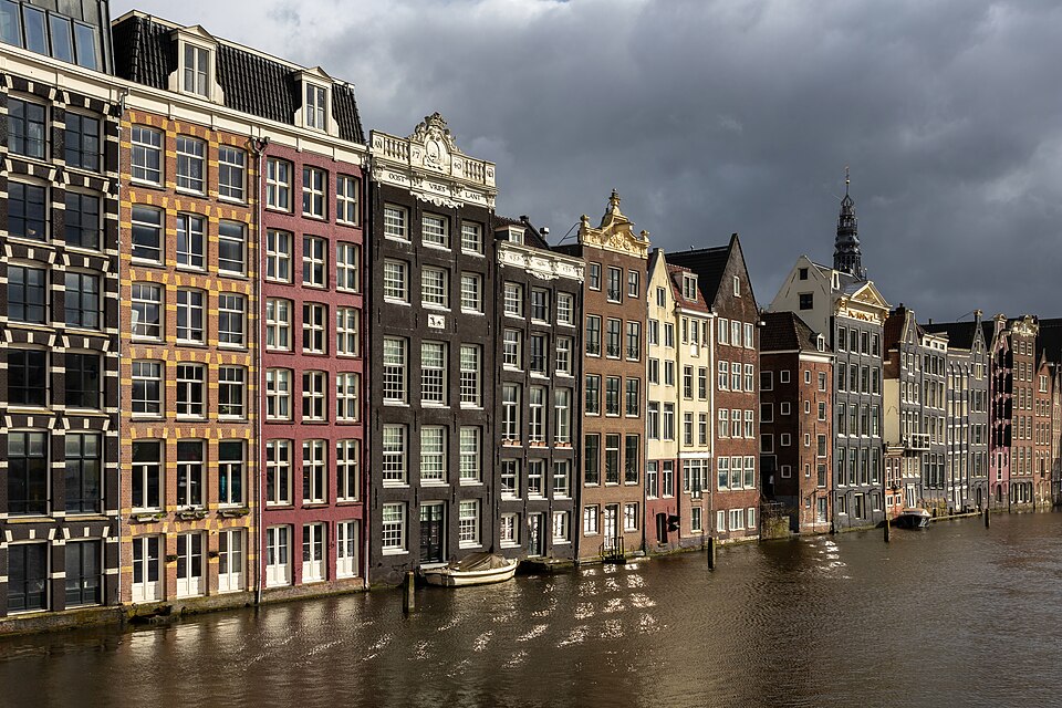 Colorful canal houses at golden hour in Damrak avenue Amsterdam the Netherlands, niederlande